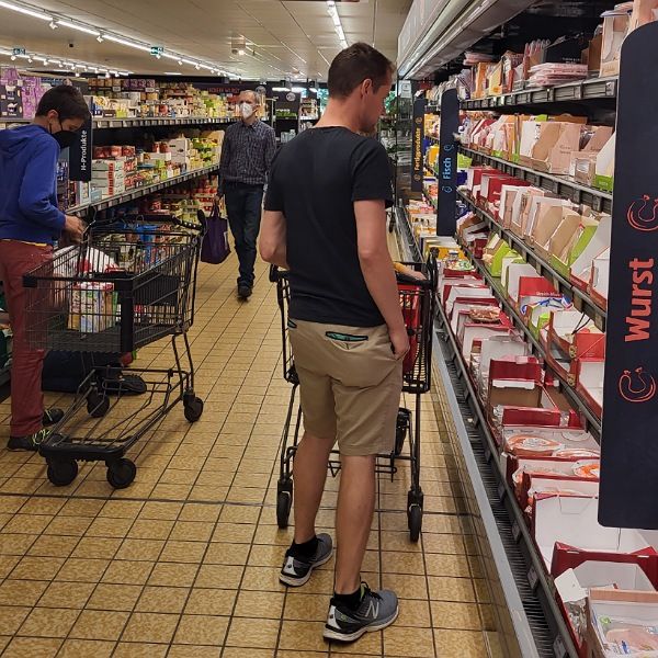 Mann im Supermarkt vor Frischetheke