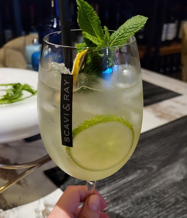Cocktail mit Limettenscheibe und Strohhalm