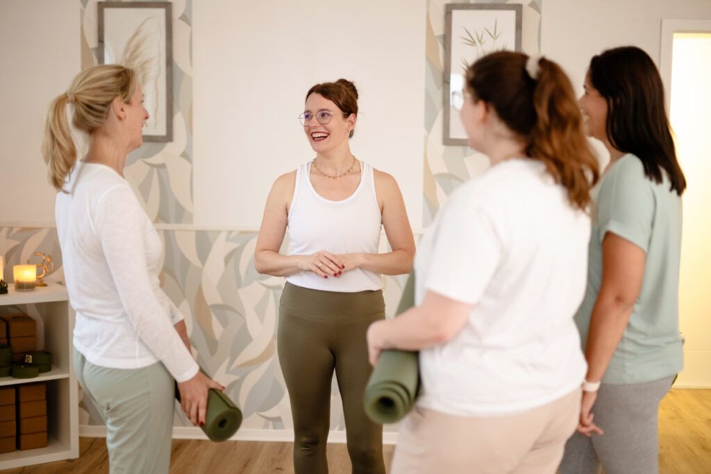 Yogalehrerin umringt von ihren Schülern im Yoga-Studio. 